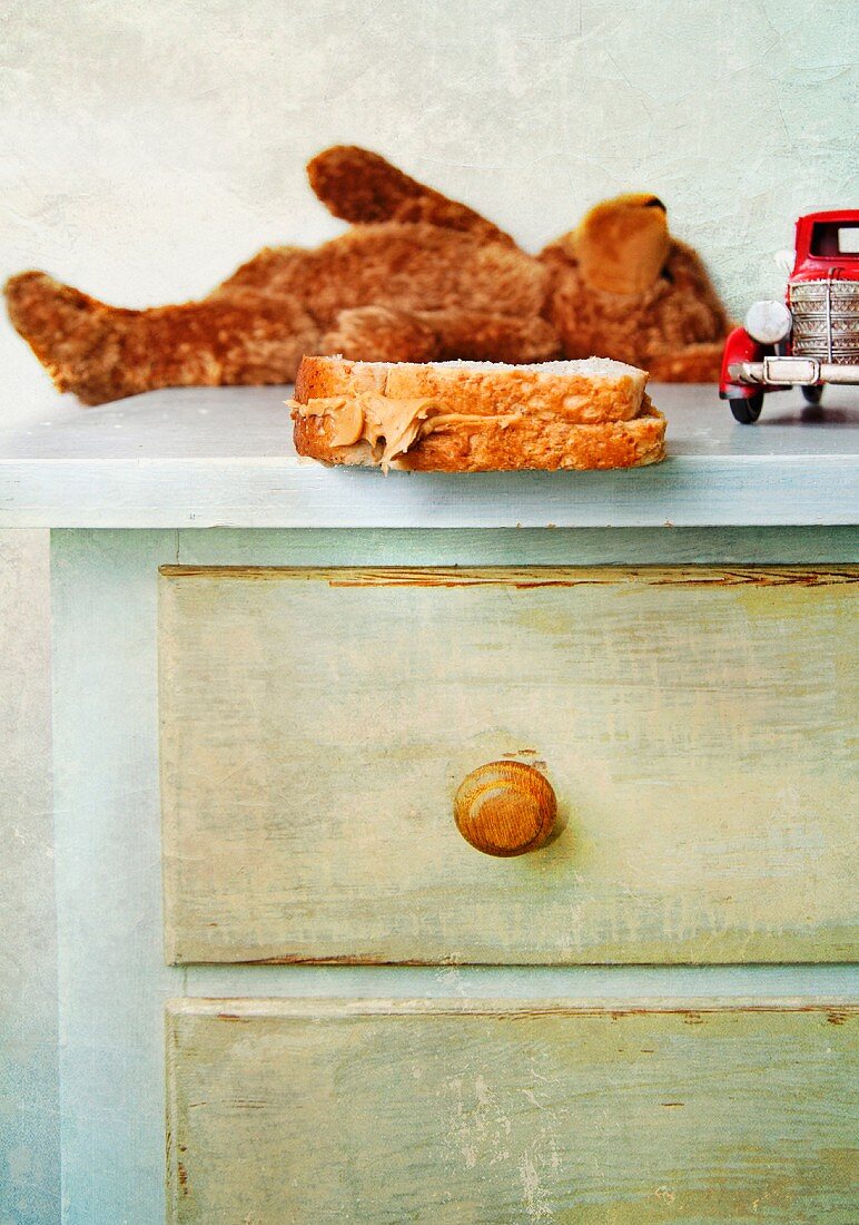 Peanut butter sandwich on a child s dresser with toys