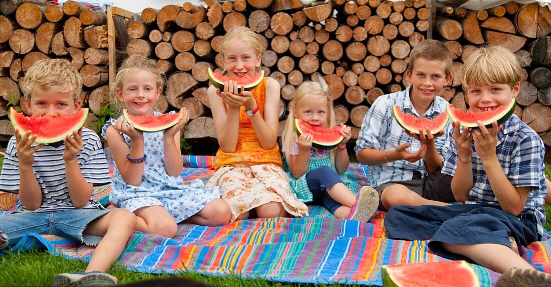Germany, Bavaria, Group of children eating watermelon