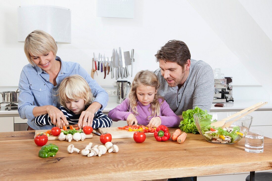 Eltern kochen zusammen mit den Kindern