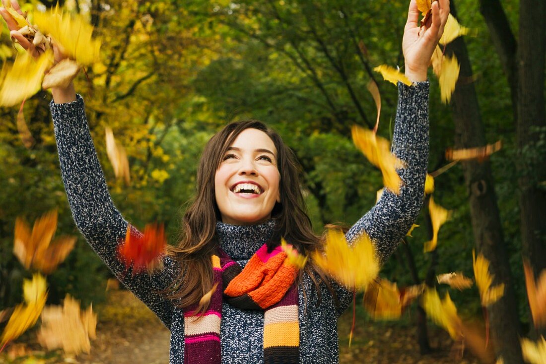 Woman playing with autumn leaves