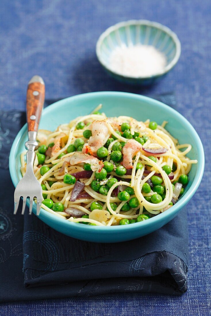 Spaghetti with peas, bacon and red onions