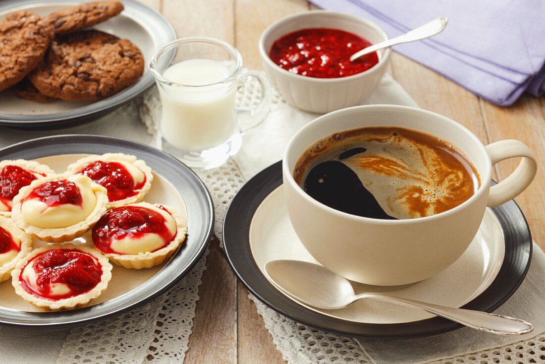 Kaffee und Minitörtchen mit Vanillemousse und Fruchtsauce