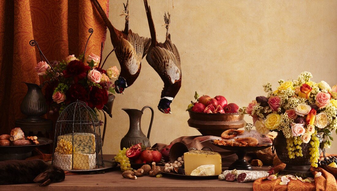 Rustikales Stillleben mit Fasanen, Hase, Käse und Früchten