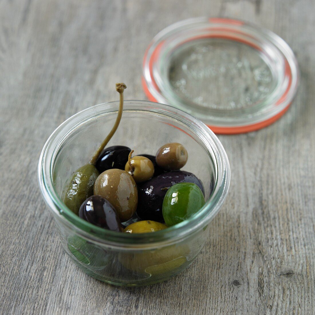 Eingelegte Oliven und Riesenkapern im Glas