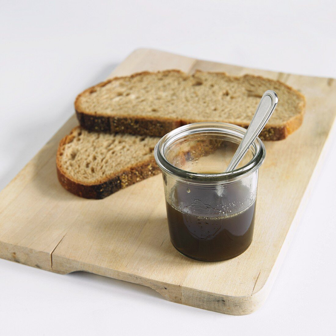 Sugar Beet Syrup with Slices of Bread on a Cutting Board