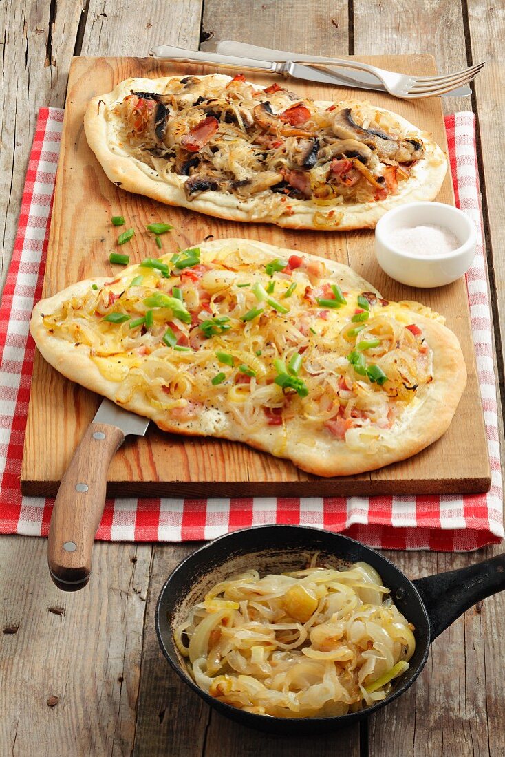 Zwei Flammenkuchen (Sauerkraut, Pilze, Bacon und Zwiebeln, Käse, Bacon)