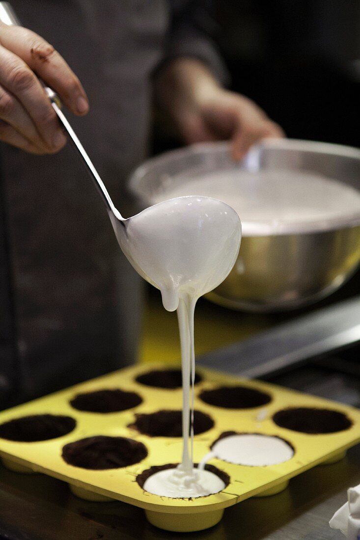 Batter being poured into a muffin tin