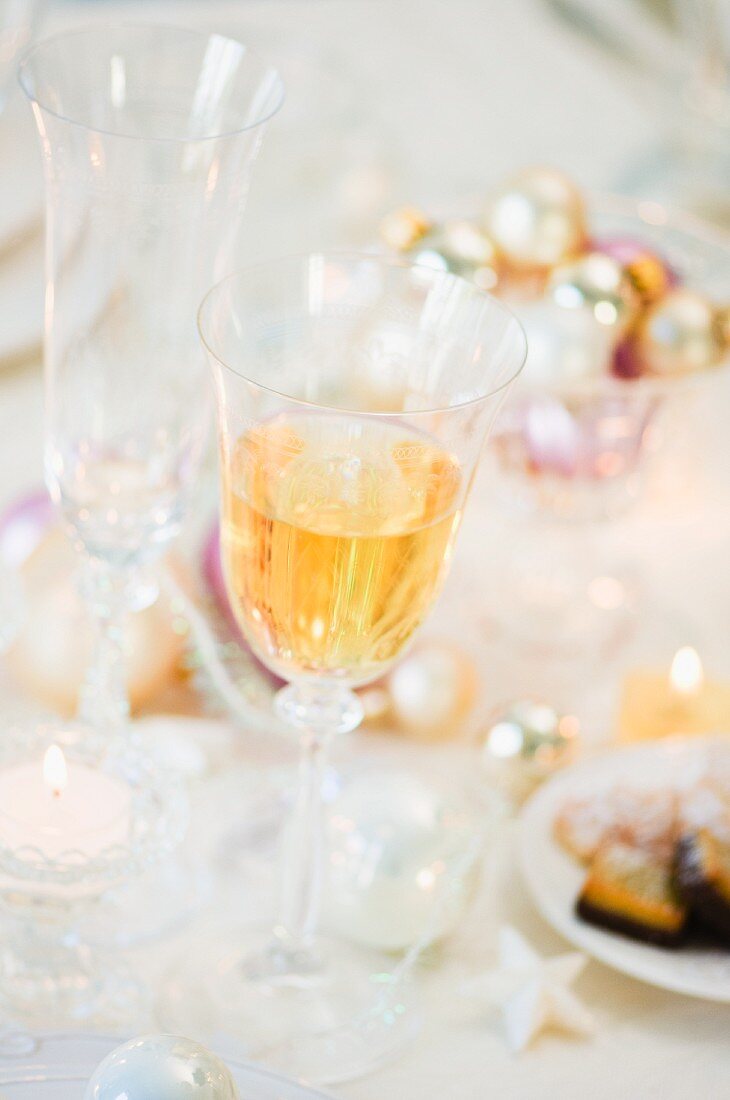 A Christmas table laid with wine, champagne glasses and baked goods