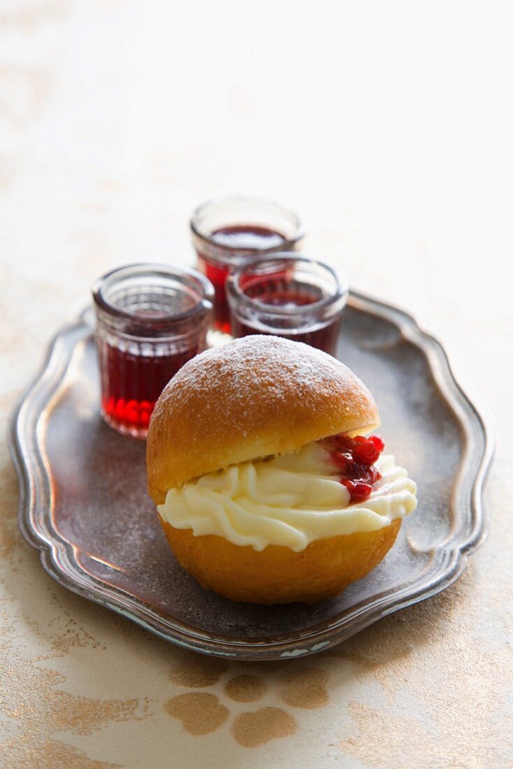 A doughnut filled with cream, with berry jelly