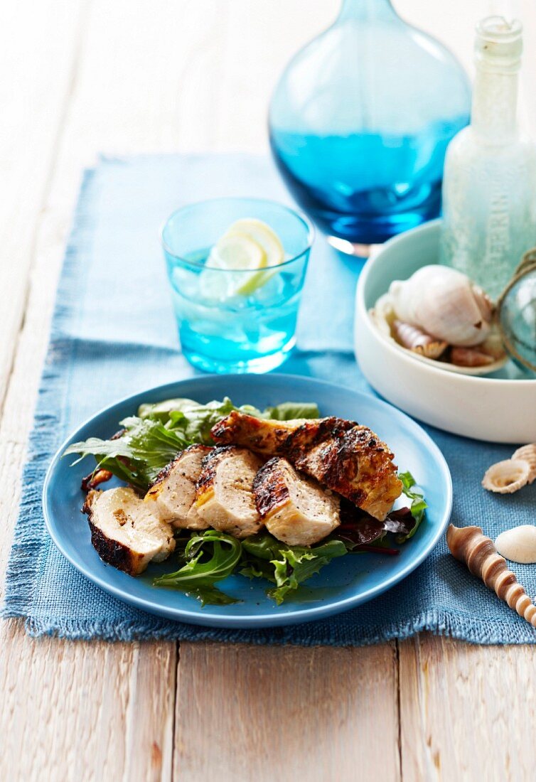 Marinierte Hähnchenbrust vom Grill auf grünem Salat