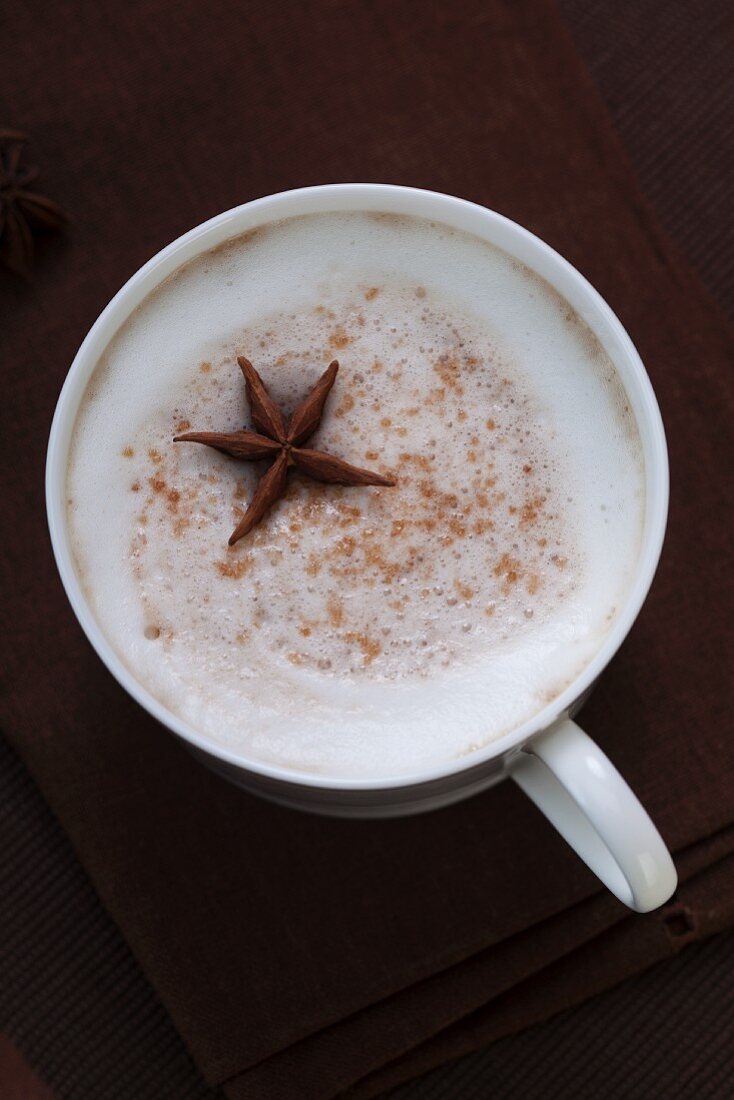 Cappuccino with Frothy Milk and Star Anise; From Above on a Black Background