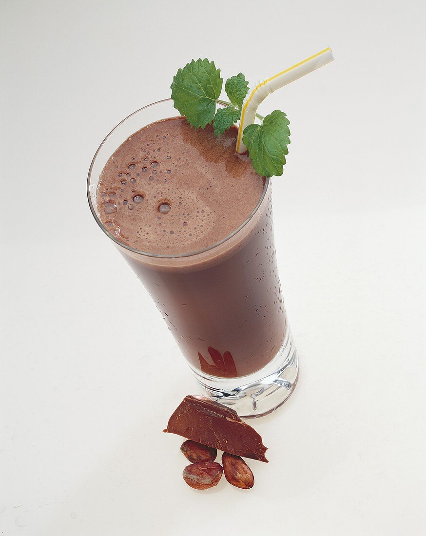 Schokoladen-Milchshake im Glas mit Strohhalm & Minze