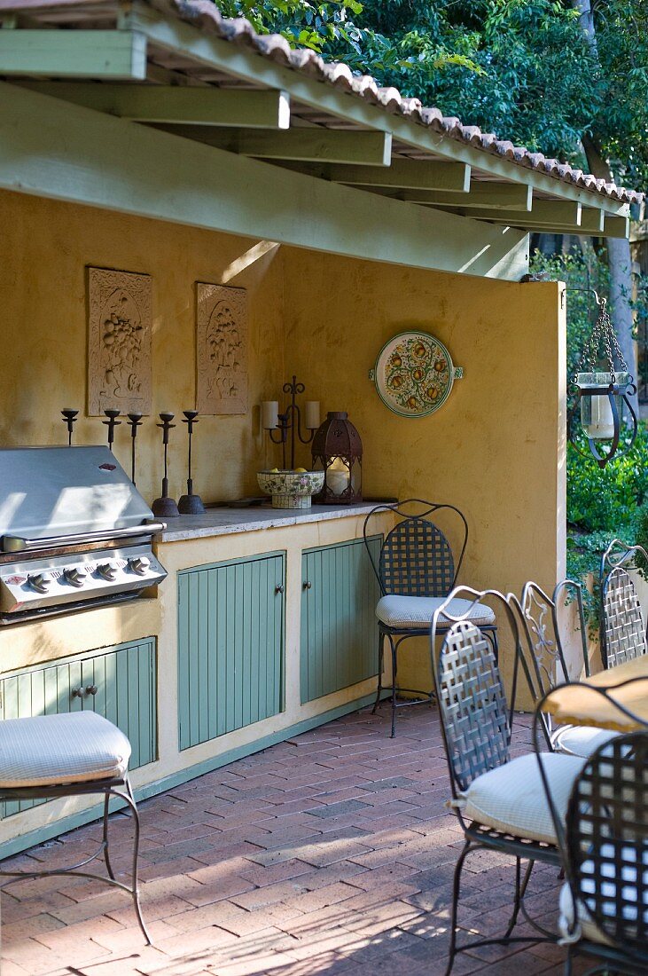 Open-air kitchen counter with built-in barbeque on partially roofed terrace