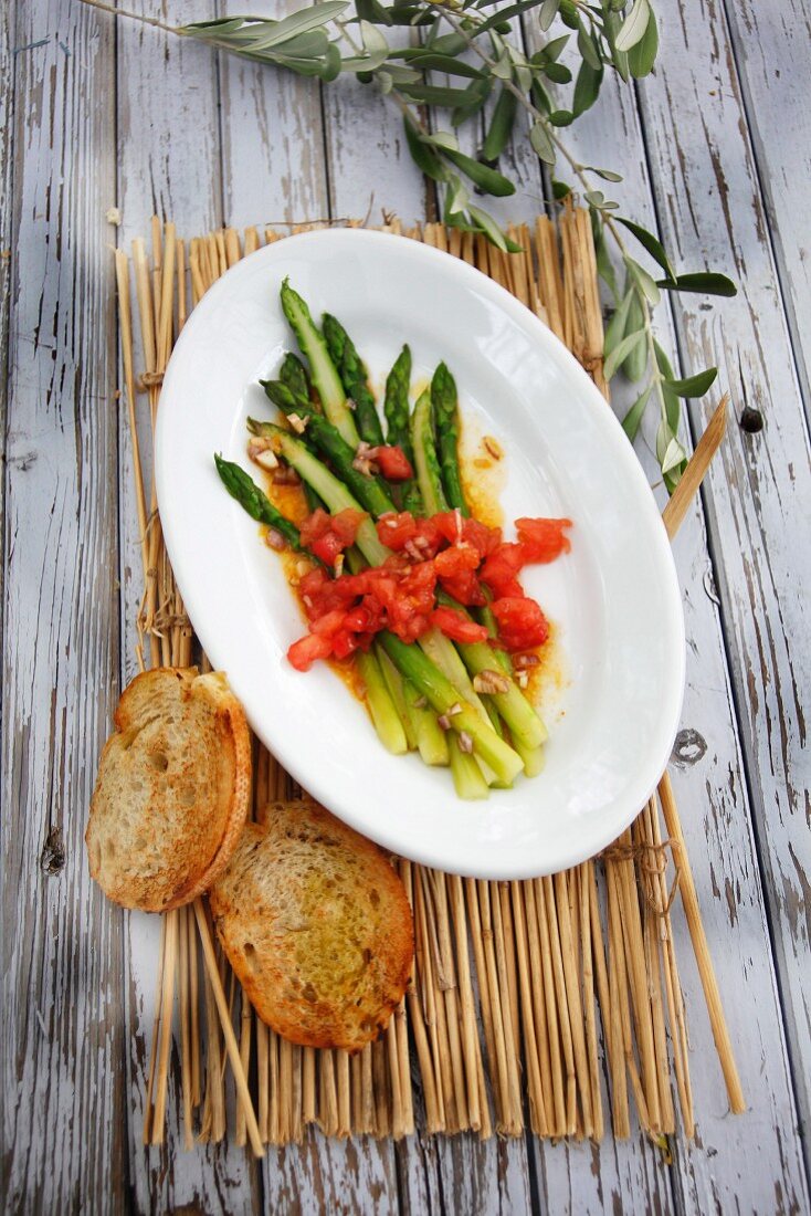 Green asparagus salad with diced tomatoes and toasted baguette slices