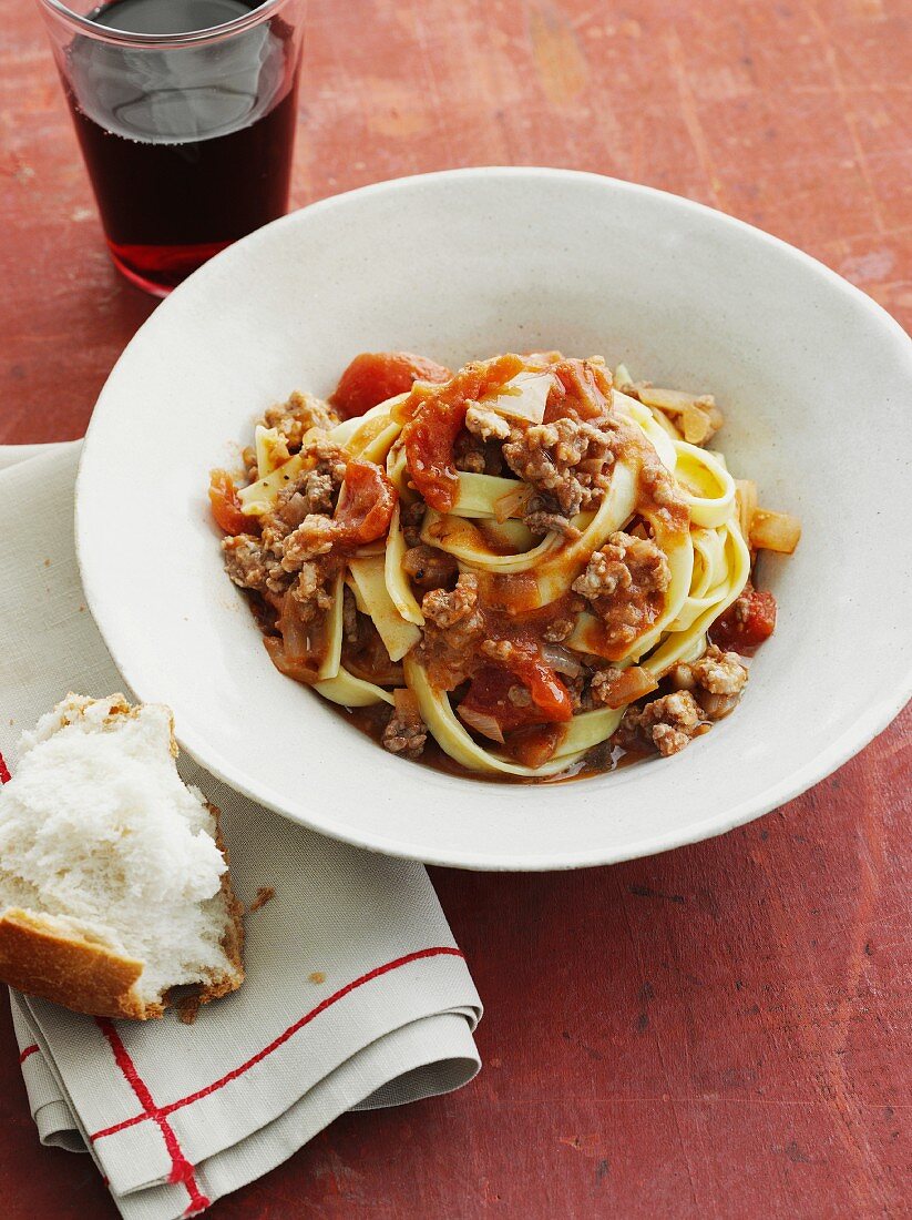 Fettuccine with bolognese sauce and a piece of bread