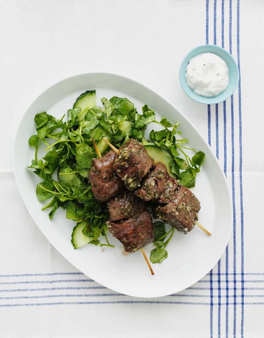 Skewers of beef on a bed of salad