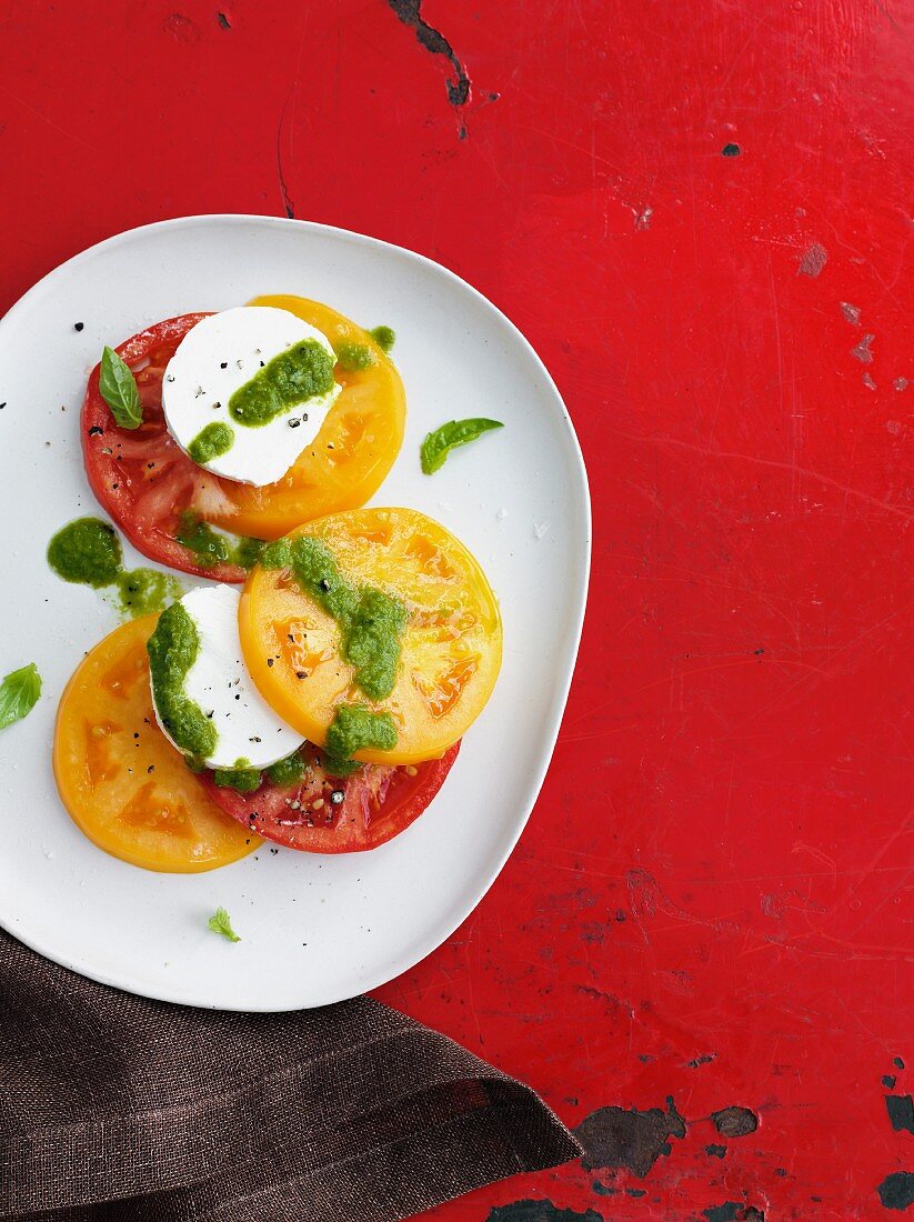 Red and yellow tomatoes with mozzarella and pesto