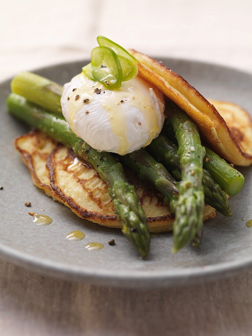 Pancakes topped with asparagus and a poached egg