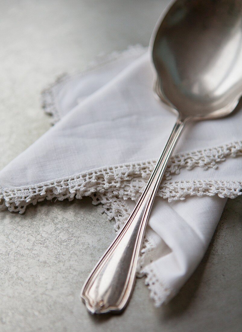 A sauce spoon on a lace-edged napkin