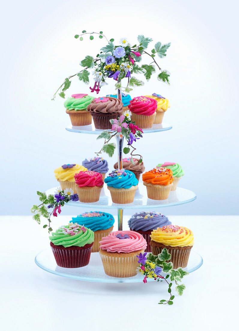 A tiered cake stand with lots of colourful cupcakes