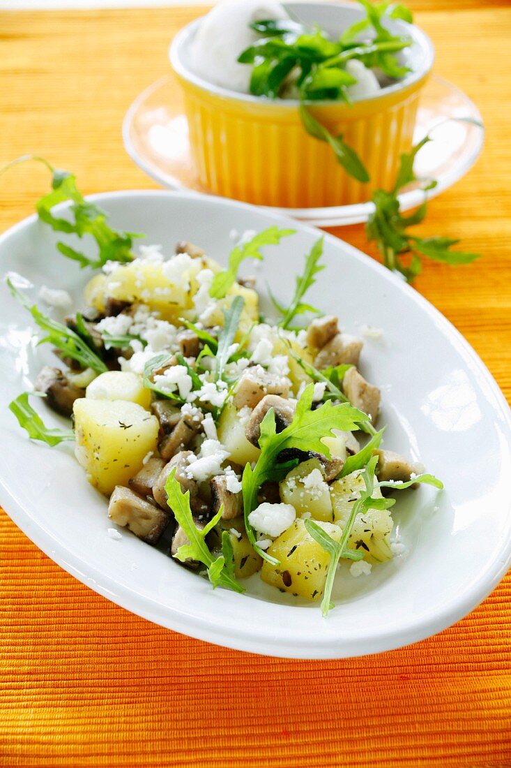 Pan-fried potatoes and mushrooms with rocket and sheep's cheese