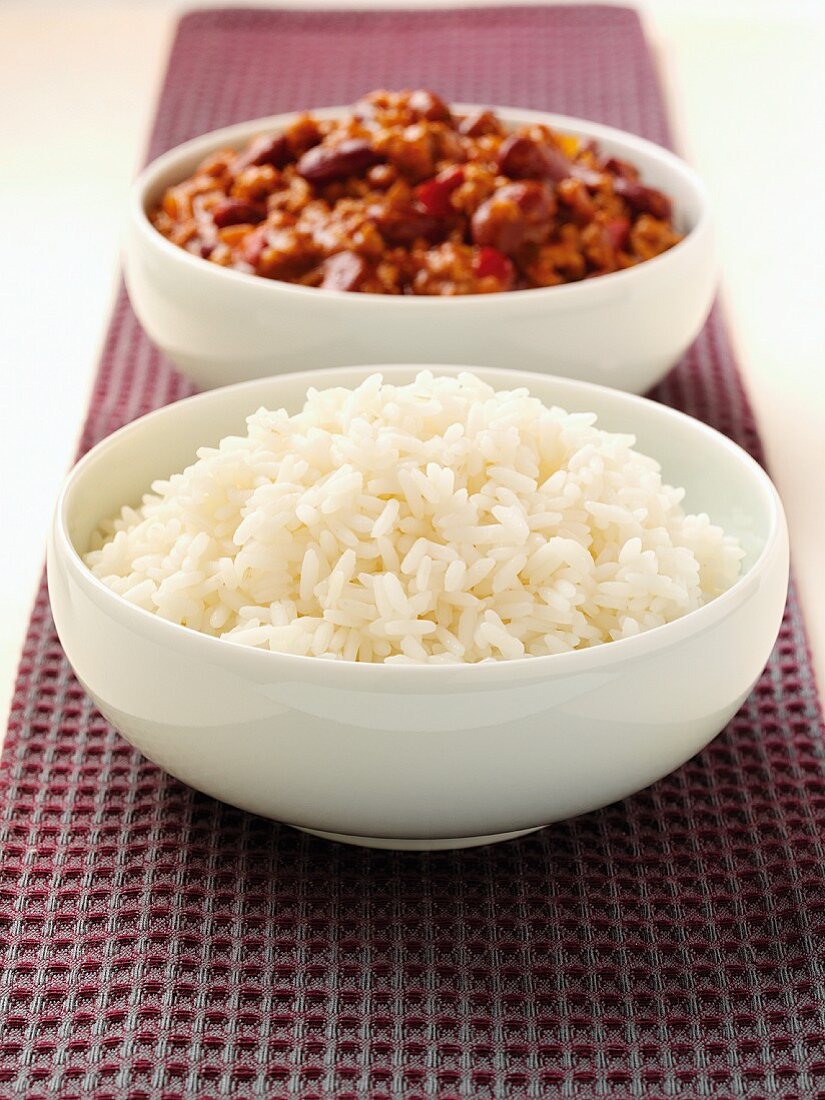 A bowl of rice and a bowl of chilli con carne