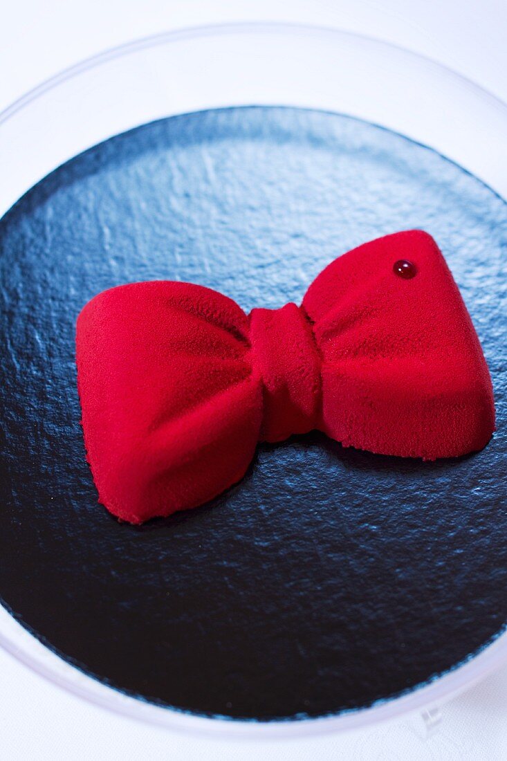 A chocolate cake topped with a red ribbon