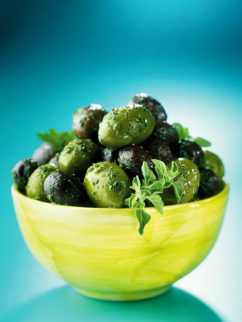 Grüne und schwarze Oliven mit Kräutern