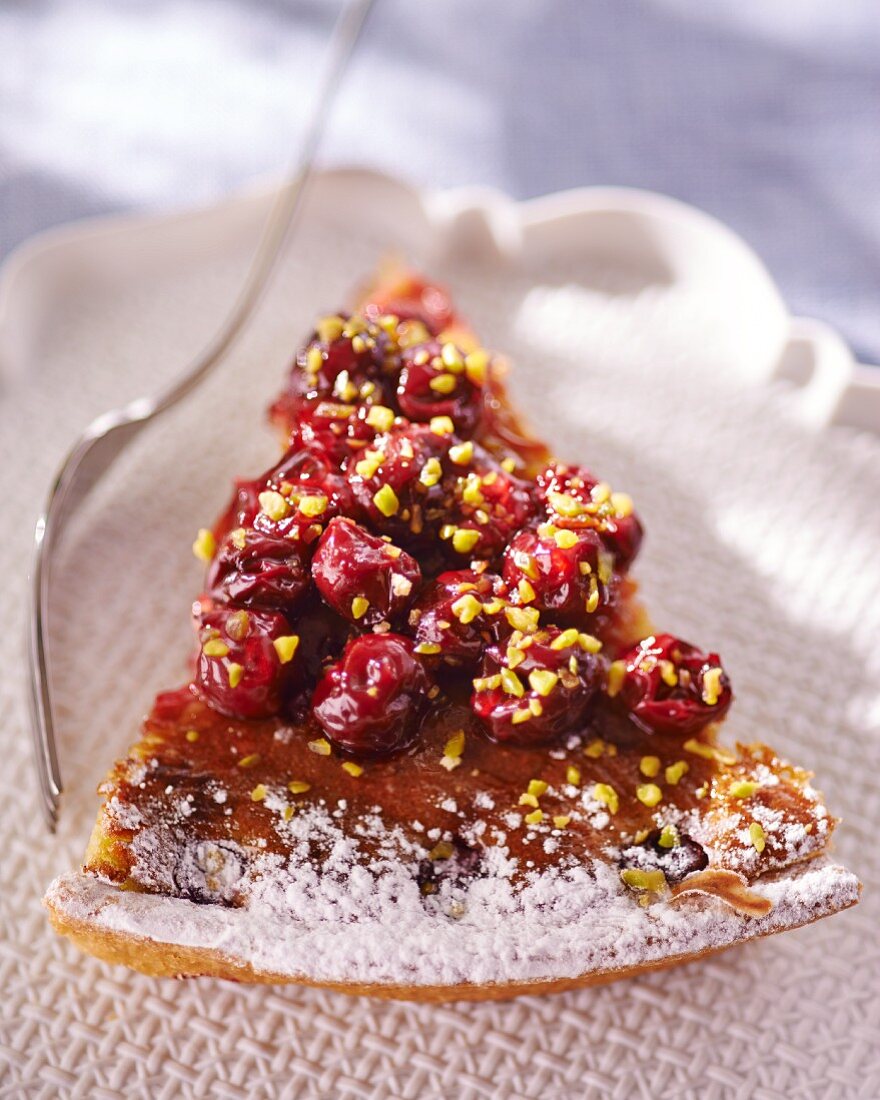 A slice of sour cherry tart with pistachios