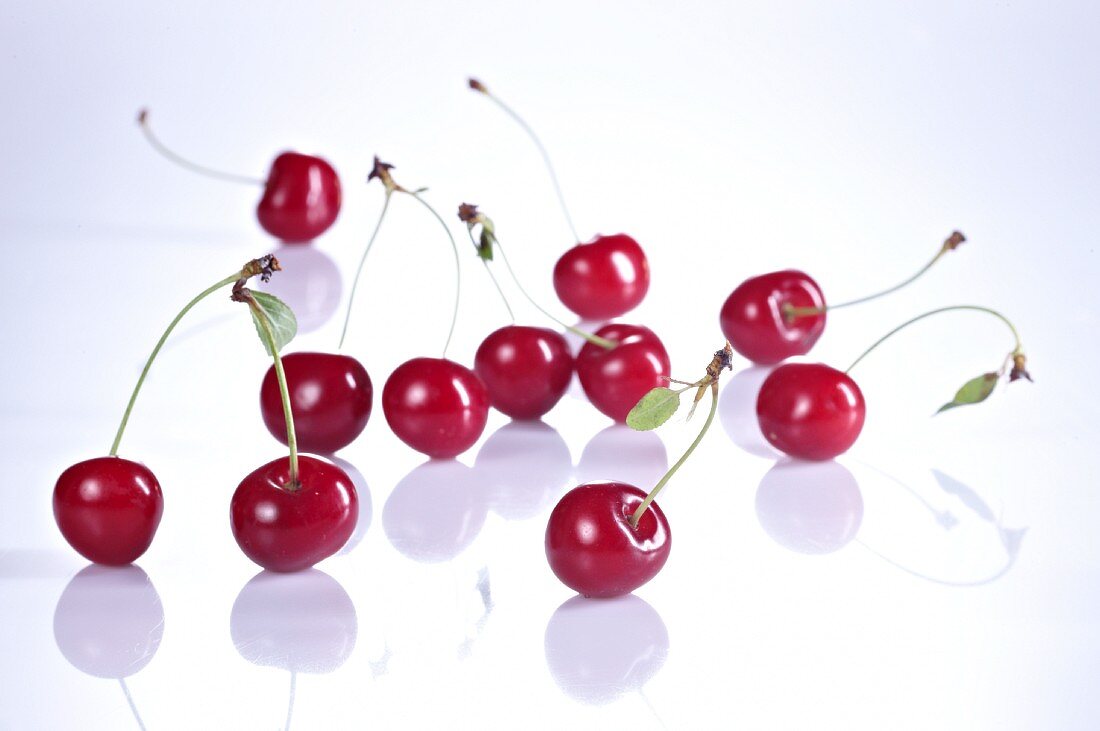 Several sour cherries with stalks and leaves