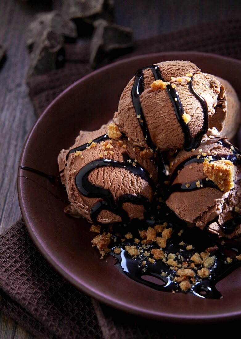 Several scoops of chocolate ice cream with chocolate sauce