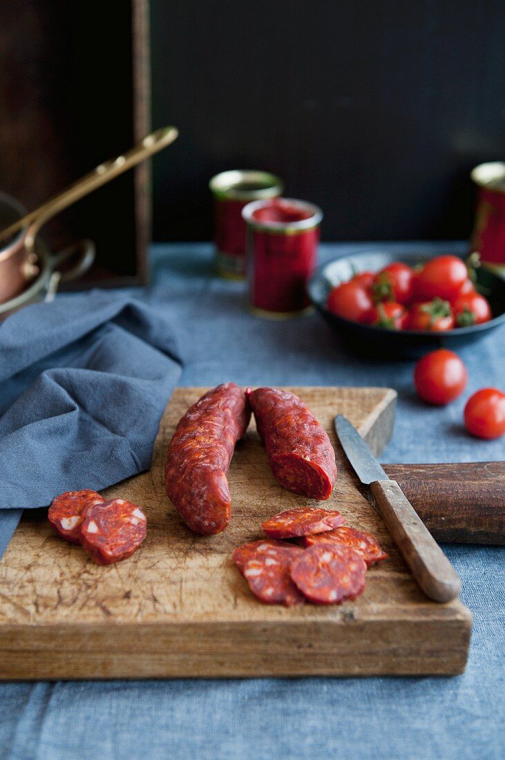 Cured sausage with paprika, on a chopping board