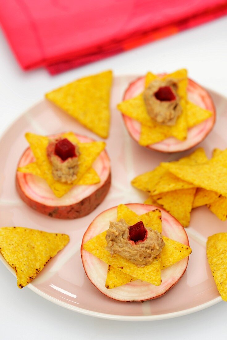 Sliced turnip topped with tortilla chips and aubergine caviar
