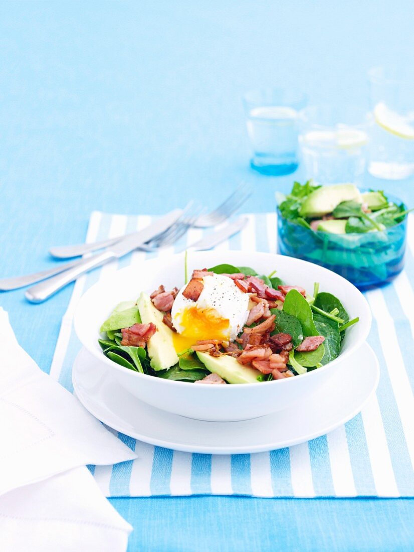 A salad of spinach, bacon and poached egg