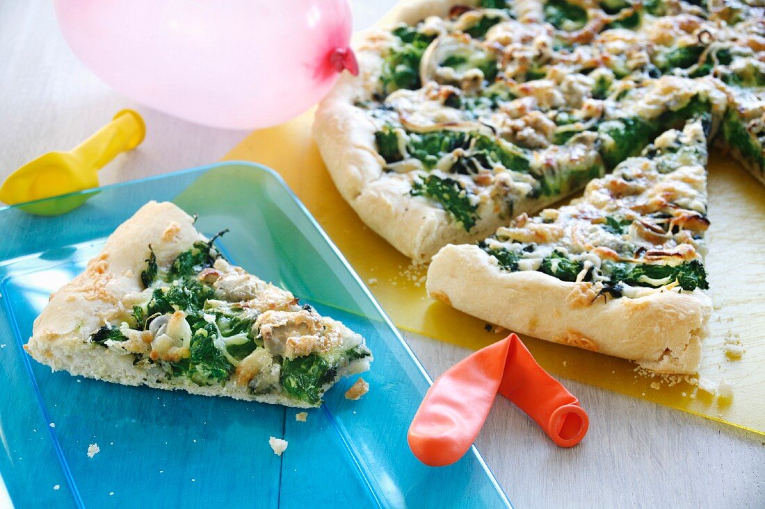 A child's pizza topped with spinach and Gorgonzola