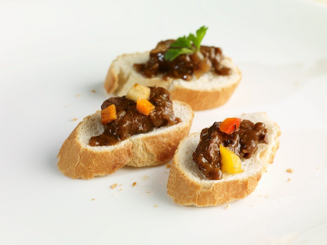 Slices of white bread with three types of goulash