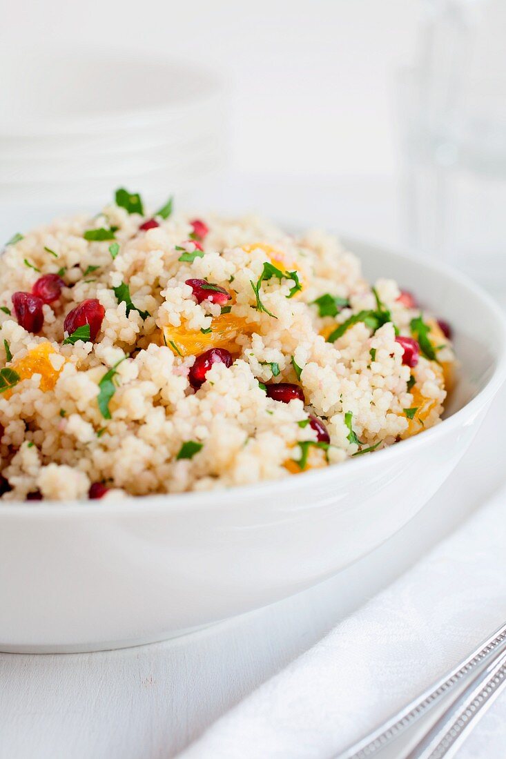 Cous cous salad with pomegranate seeds, clementine, chopped mint and flat leaf parsley