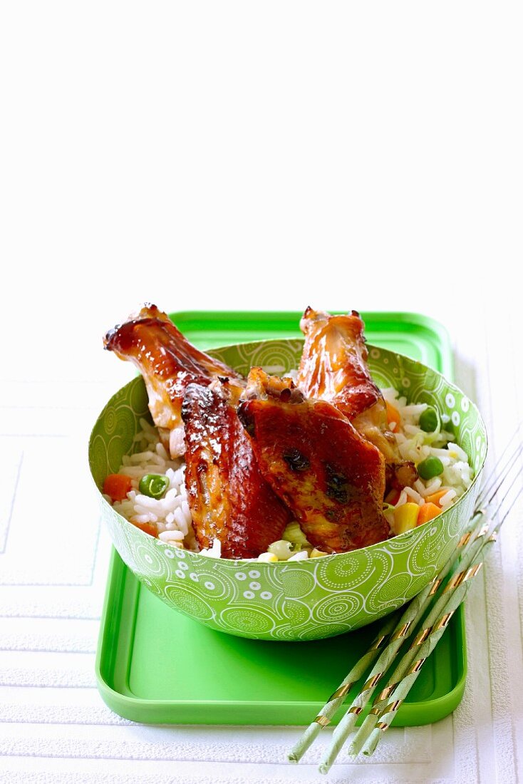 Glazed chicken wings on vegetable rice