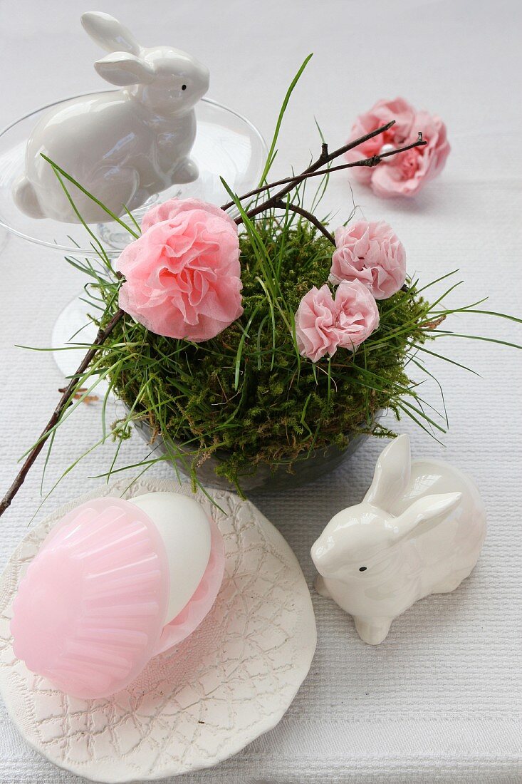 An idea for an Easter decoration: a porcelain hare, and paper pinks in a nest made of moss