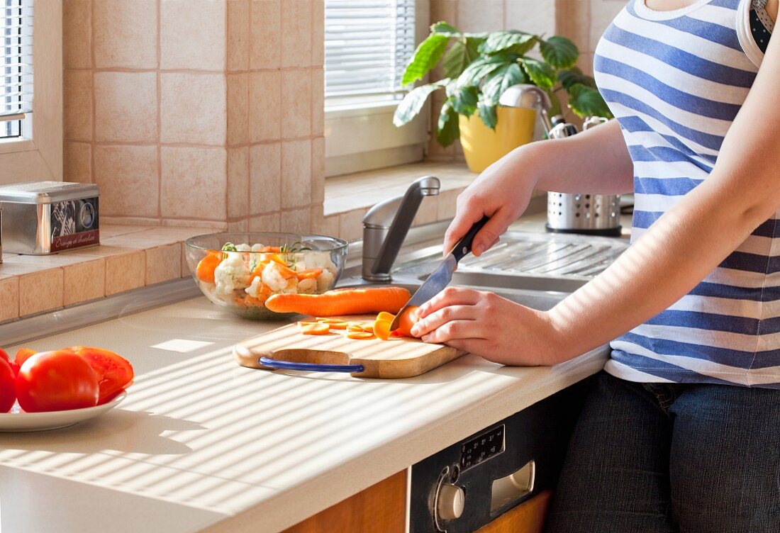 A woman cutting carrots