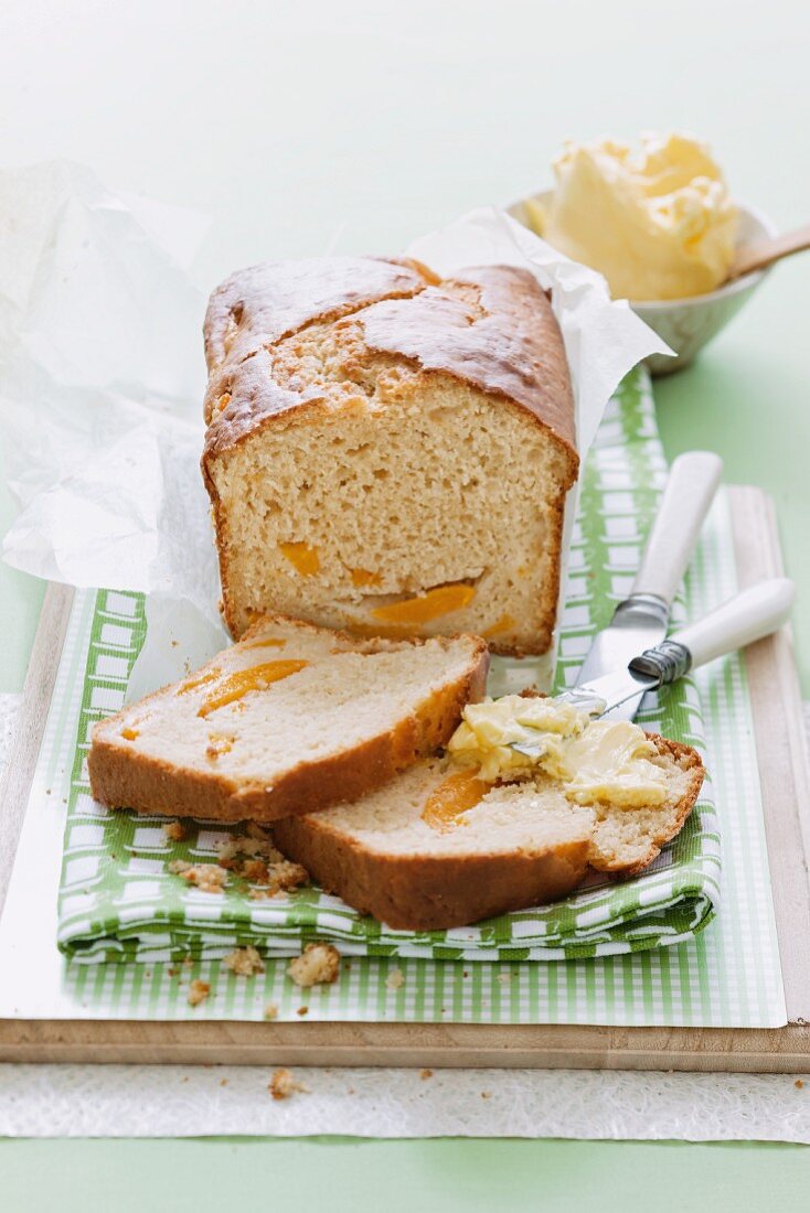 Peach and passion fruit bread, one slice spread with butter