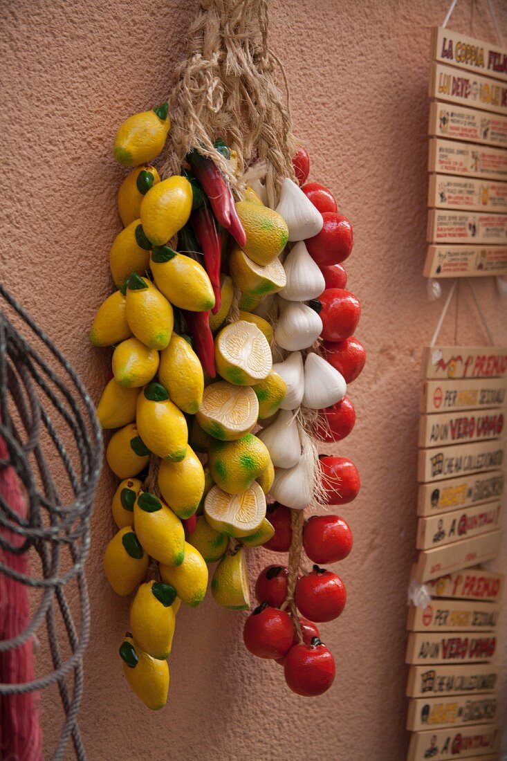 Keramikfrüchte an einer Hauswand hängend