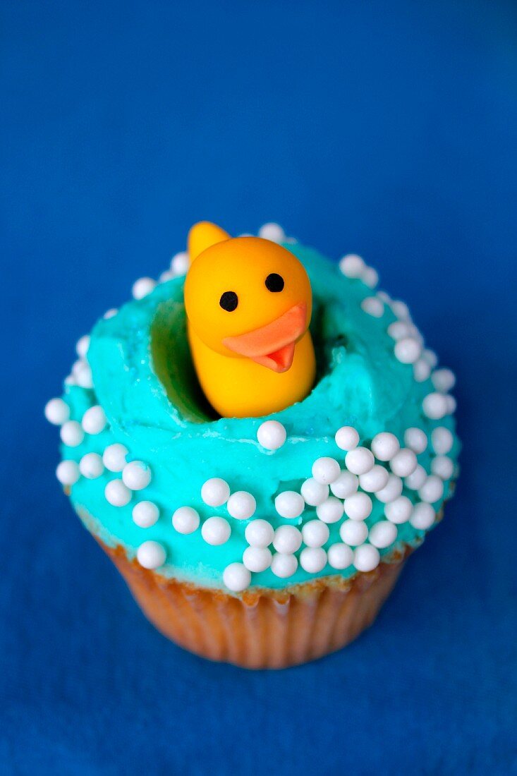 A cupcake topped with a rubber duck