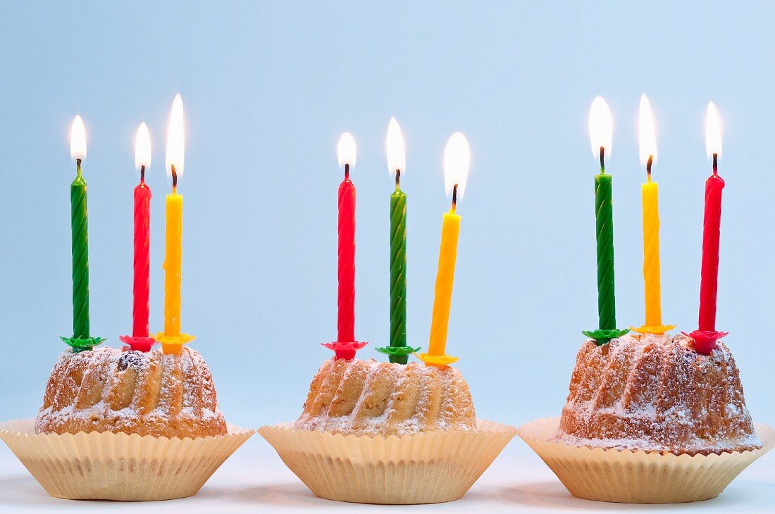 Three Bundt cakes with lit candles, for a birthday