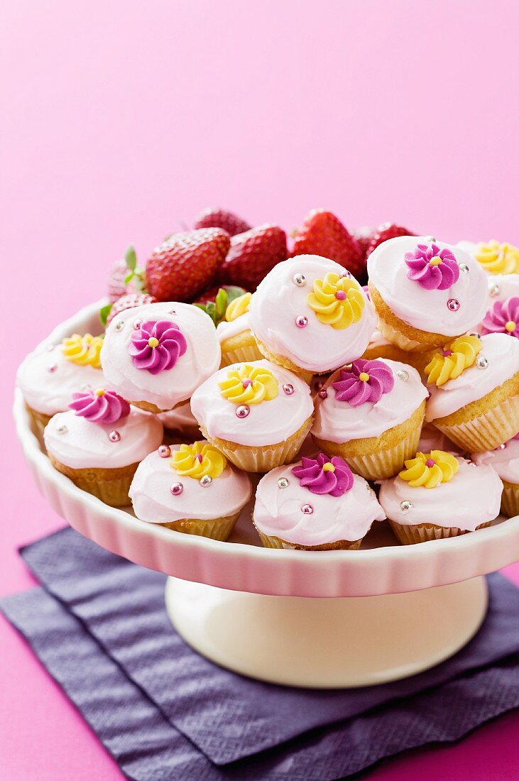 Viele Mini-Cupcakes , mit Zuckerblumen verziert, auf Kuchenständer