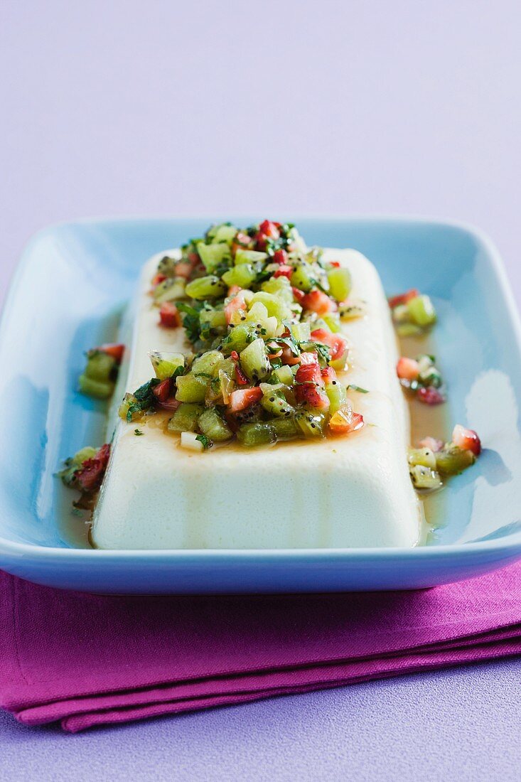 Panna cotta terrine topped with chopped kiwis, strawberries and mint