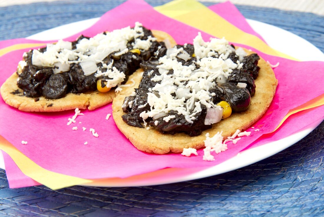 Tlacoyos (ovale Maistortilla) mit Huitlacoche (Maispilz) und Käse (Mexiko)