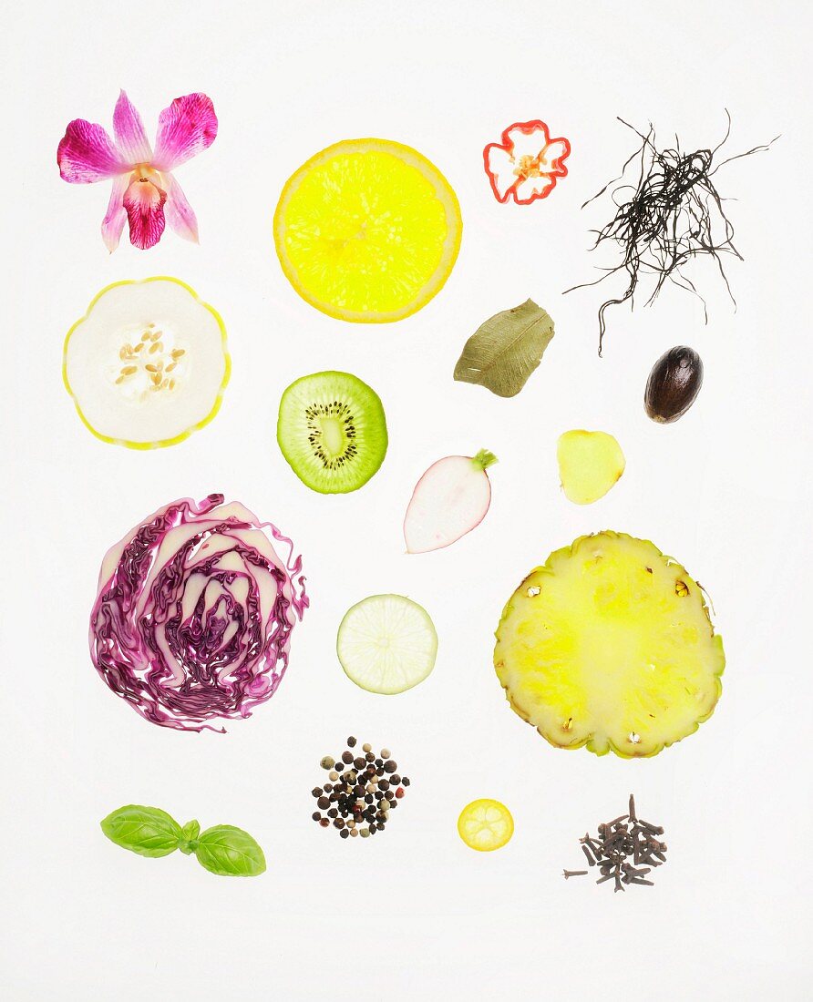 Assorted Slices of Vegetables, Fruit, Herbs and Seeds on a White Background