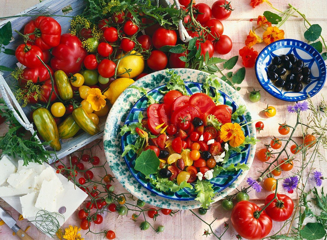 A salad of tomatoes, olives, sheep's cheese and nasturtiums