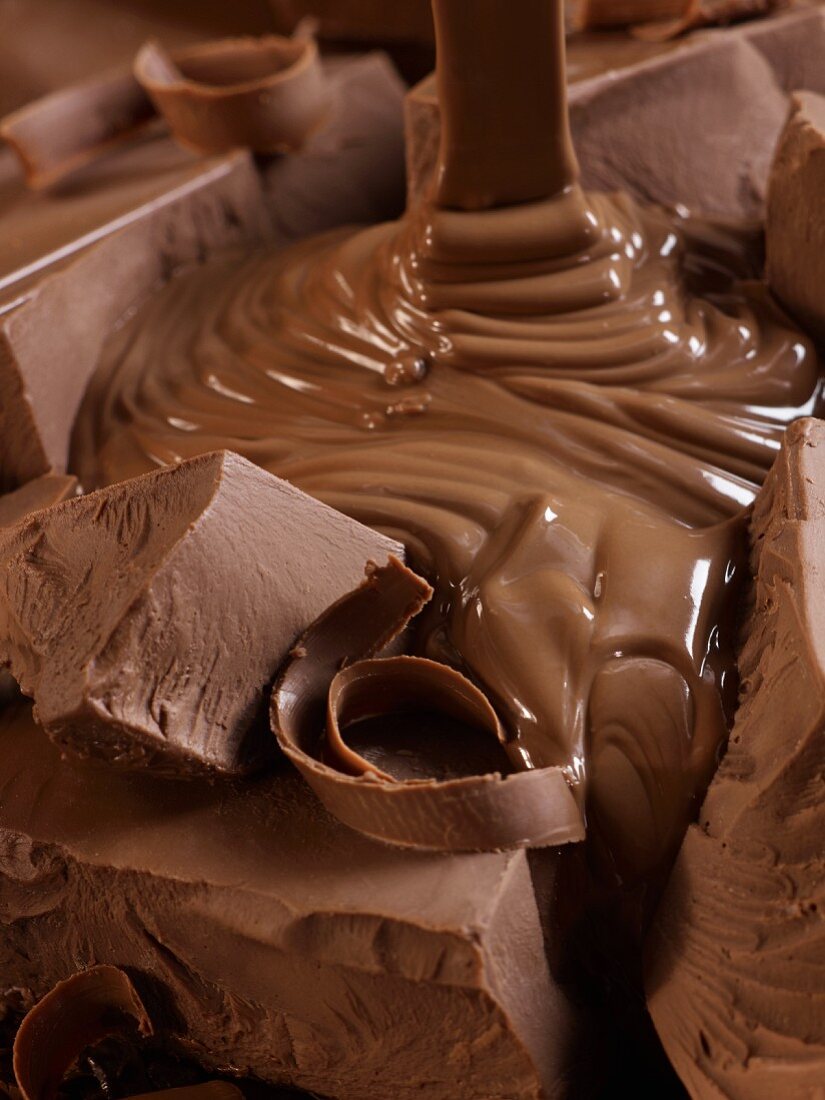 Flüssige Schokolade fließt über Schokostücke